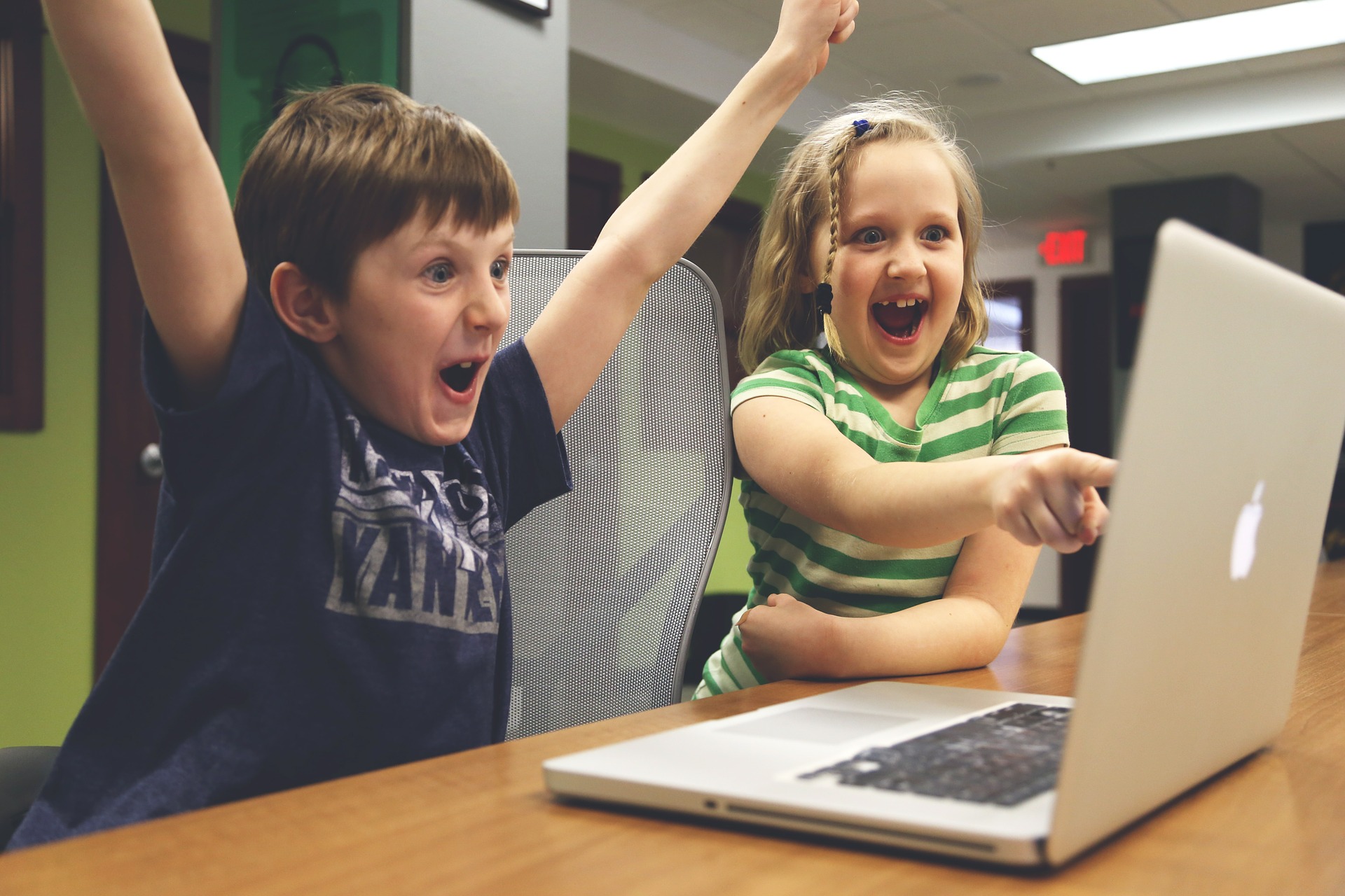 Happy children pointing at laptop