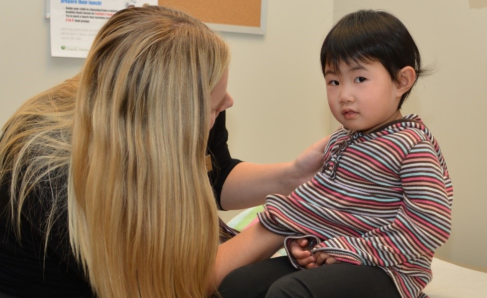 Doctor examining young boy on table