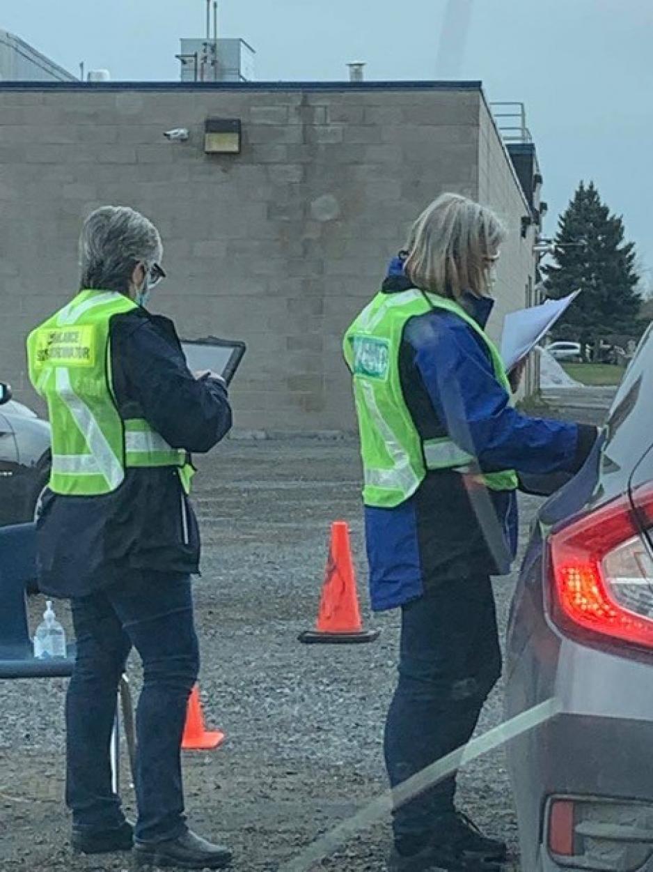 2 health care workers at a patient's car