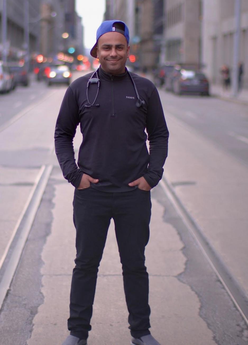 naheed dosani stands with his hands in his pockets in the middle of a city street