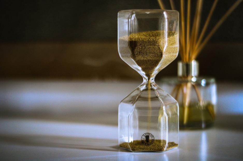 Hourglass Hourglass casting shadows with reed diffuser in background
